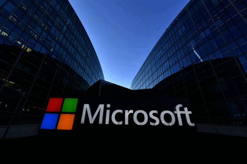 办公室内员工正在使用电脑进行远程会议的画面