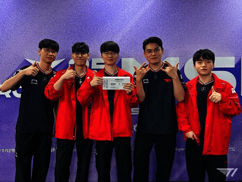 观众席上T1粉丝挥舞应援旗帜，现场氛围热烈高涨