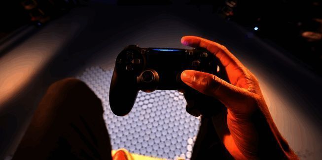 迪士尼乐园内展示中的BDX多罗伊朵机器人,外观拟人化,配备双足结构,前方为手持Steam Deck的操作员