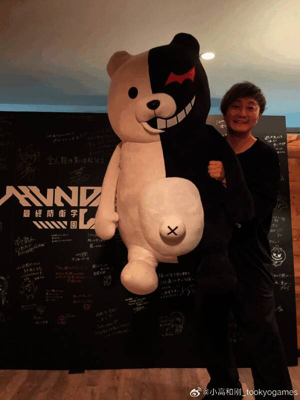 小高和刚手持黑白熊玩偶的生日合影，背景为游戏元素装饰