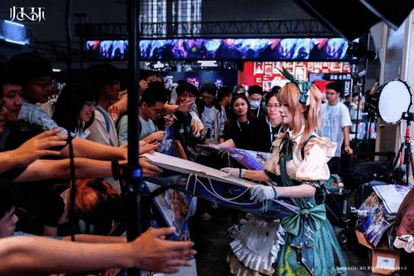 《归环》展台前玩家排队领取限量周边,工作人员正在发放礼品