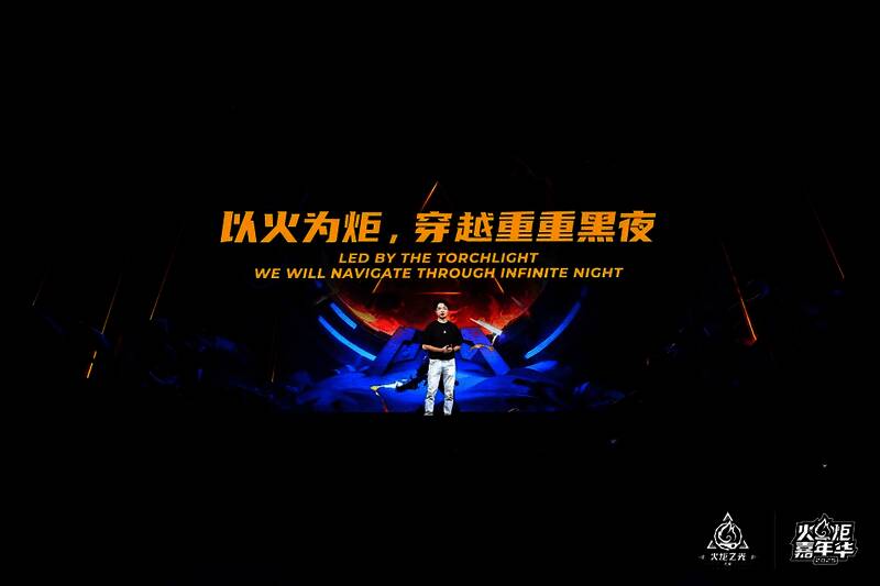 制作人刘恒在舞台上激情演讲,背后大屏幕显示游戏发展历程