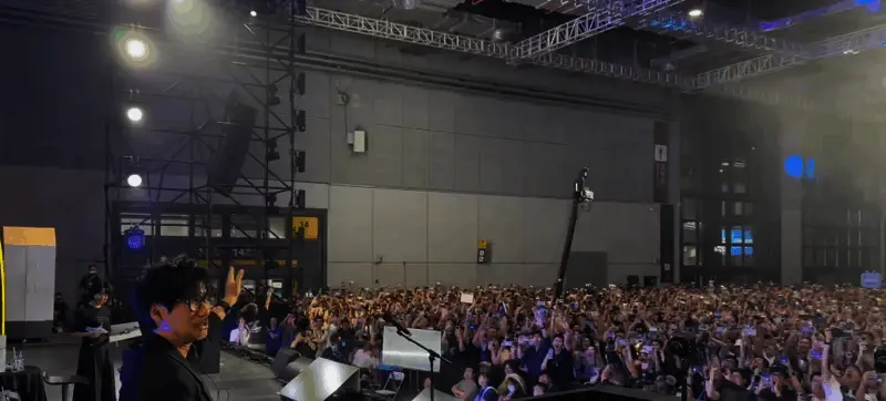 小岛秀夫在上海街头参观游戏主题咖啡馆,面带好奇微笑