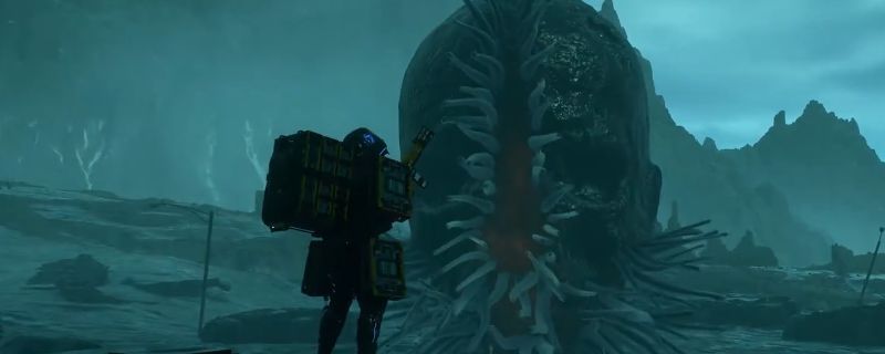 《死亡搁浅2》中裂口鱼BOSS的战斗画面，其巨大的裂口状头部清晰可见，周围环境阴暗潮湿，充满神秘气息