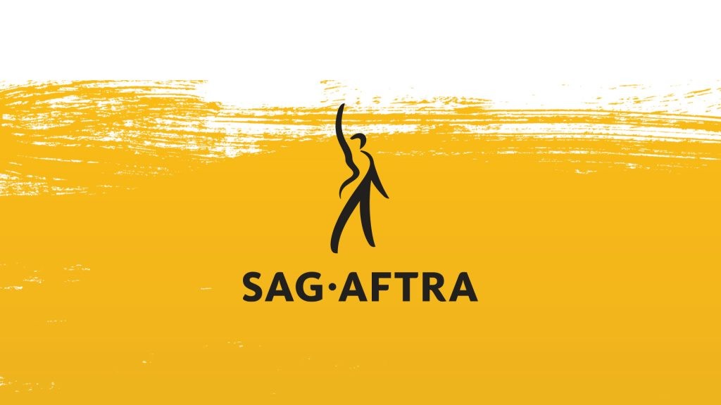 SAG-AFTRA工会代表与多家游戏公司高管在签约仪式现场合影，背景板印有‘Interactive Media Agreement 2025’字样，众人面带微笑握手致意